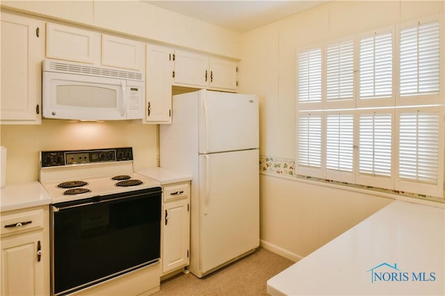 kitchen featuring light countertops, white appliances, and white cabinets