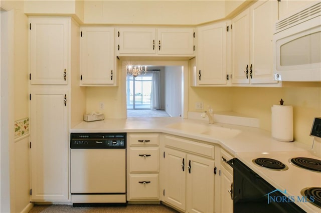 kitchen with electric stove, dishwasher, white microwave, light countertops, and a sink