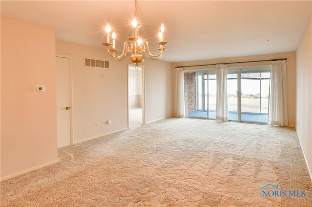 empty room featuring carpet floors, baseboards, visible vents, and a notable chandelier