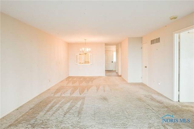 unfurnished room with a chandelier, carpet flooring, and visible vents