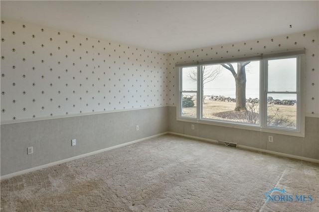 empty room with plenty of natural light, carpet flooring, and wallpapered walls