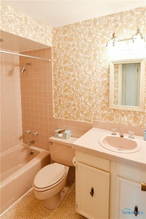 full bathroom with  shower combination, vanity, toilet, and wallpapered walls