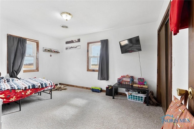 carpeted bedroom featuring baseboards and visible vents