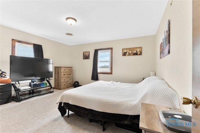 bedroom with multiple windows, carpet flooring, and visible vents