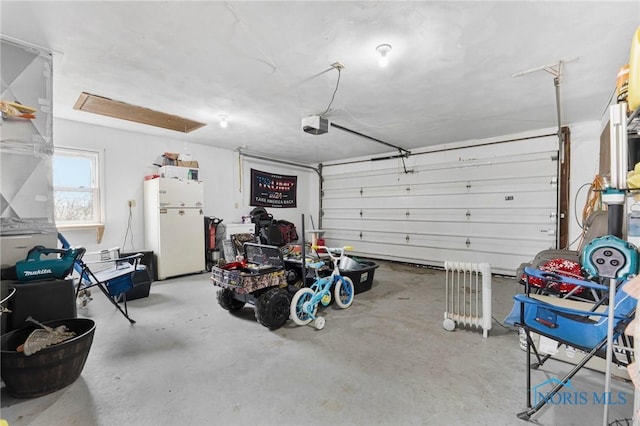 garage featuring a garage door opener and freestanding refrigerator