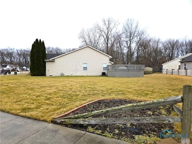 view of side of home with a lawn, a vegetable garden, and central air condition unit