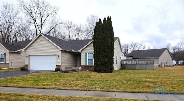 ranch-style house with driveway, an attached garage, a front lawn, and brick siding