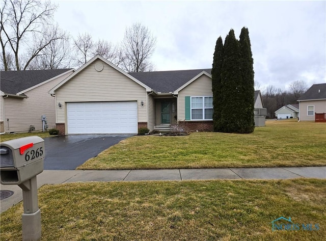 single story home with a garage, a front yard, brick siding, and driveway