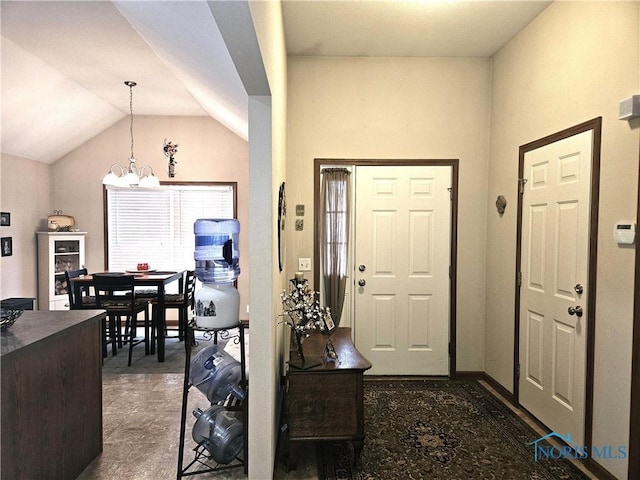 foyer entrance featuring a chandelier and vaulted ceiling