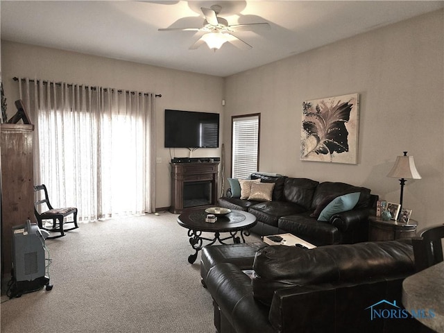 carpeted living area featuring a fireplace and ceiling fan