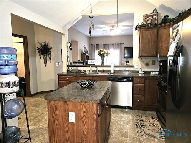 kitchen with stainless steel appliances, a kitchen island, a sink, a ceiling fan, and dark countertops