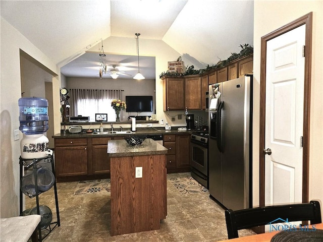 kitchen featuring dark countertops, a kitchen island, hanging light fixtures, stainless steel appliances, and a sink