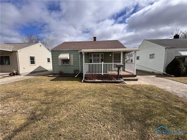 view of front of house featuring driveway, covered porch, roof with shingles, and a front yard