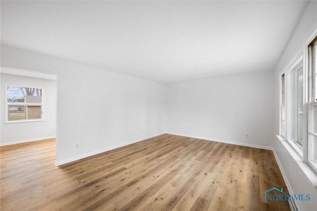 empty room with light wood-style flooring and baseboards