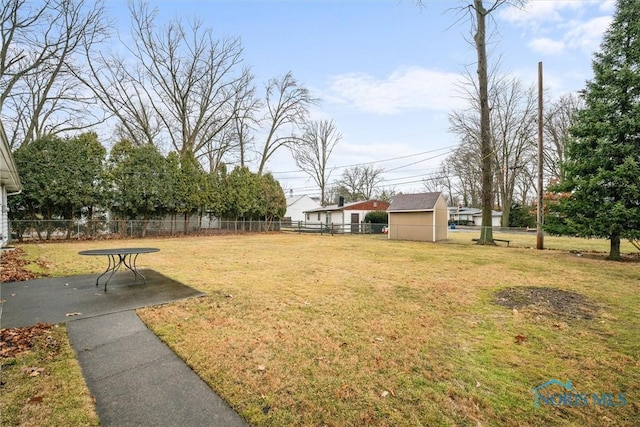 view of yard featuring a patio area, a storage shed, an outdoor structure, and fence