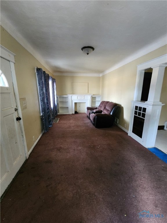 unfurnished living room featuring carpet floors and baseboards