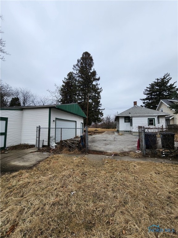 view of yard featuring a garage, fence, and an outdoor structure