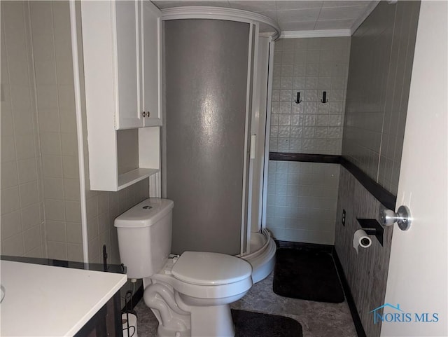 full bathroom with a shower stall, tile walls, vanity, and toilet