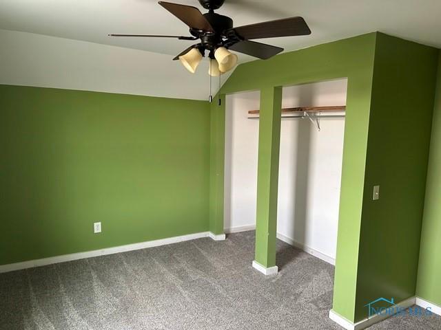 unfurnished bedroom featuring ceiling fan, a closet, carpet flooring, and baseboards