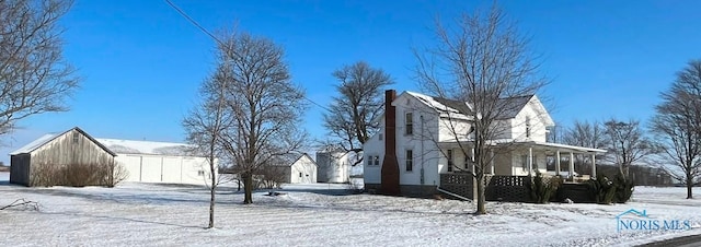 view of snowy exterior with covered porch