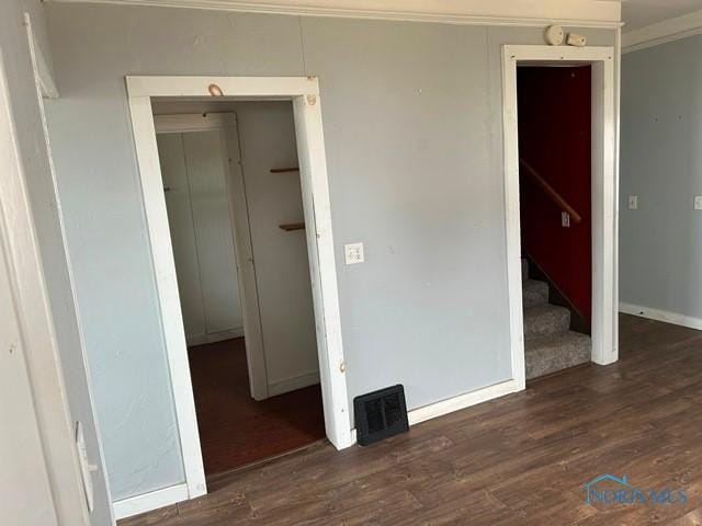 unfurnished room with stairway, wood finished floors, visible vents, and crown molding