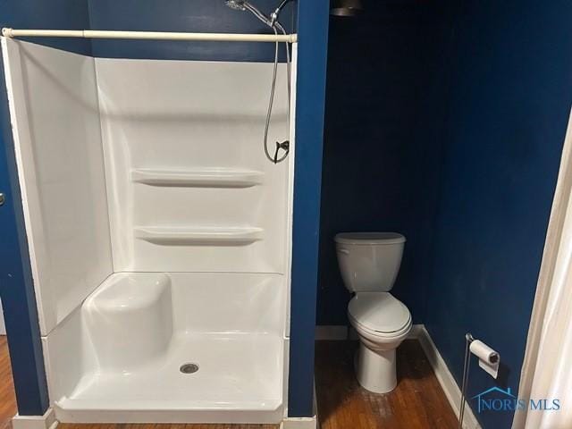 full bath with wood finished floors, baseboards, toilet, and a walk in shower