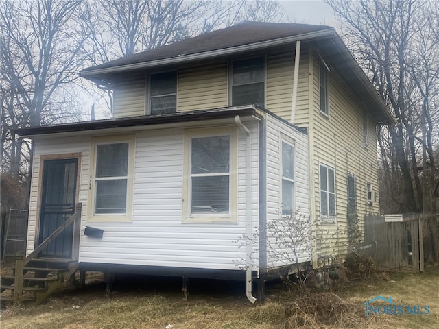 view of home's exterior with entry steps and fence