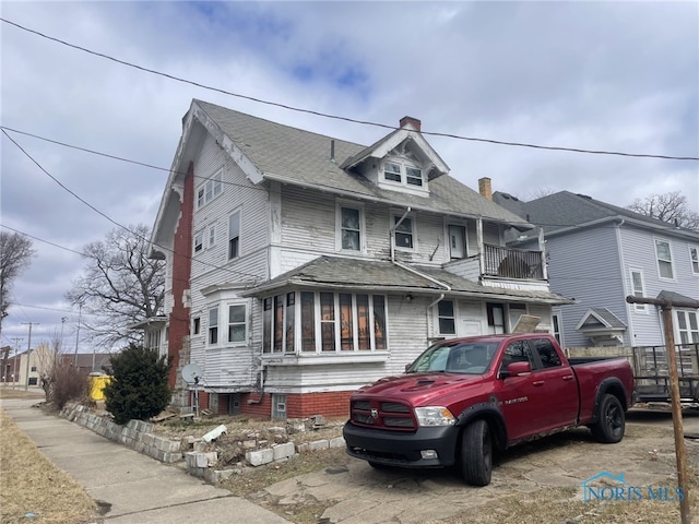 american foursquare style home featuring a chimney