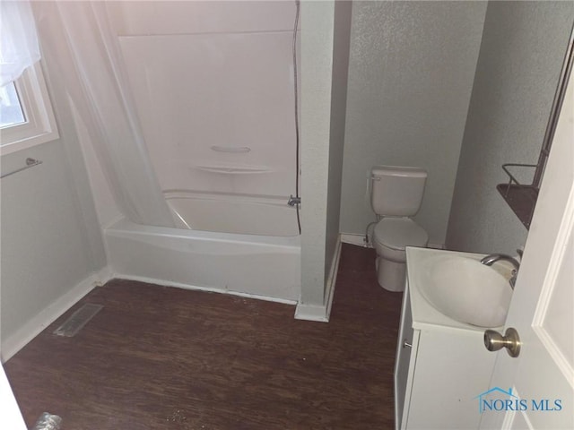 full bathroom featuring toilet, wood finished floors, visible vents, bathing tub / shower combination, and vanity