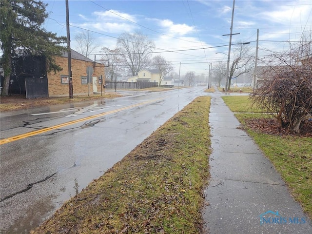 view of street with street lighting, sidewalks, and a residential view