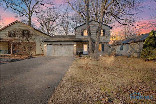 view of front facade featuring aphalt driveway and a garage