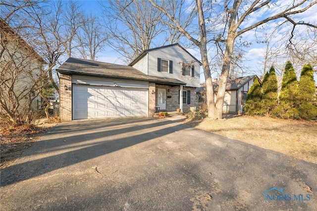 view of front of property with brick siding, an attached garage, and driveway