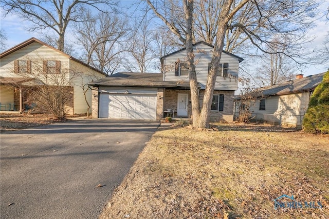 view of front of property with aphalt driveway, brick siding, and an attached garage