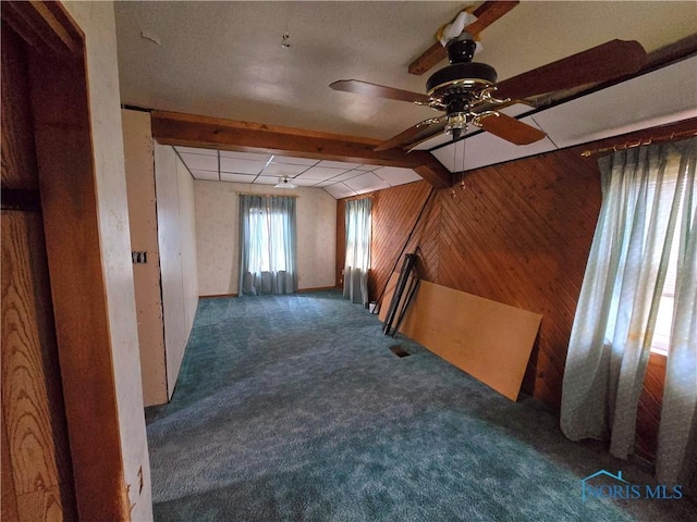 additional living space featuring carpet, beam ceiling, and wooden walls