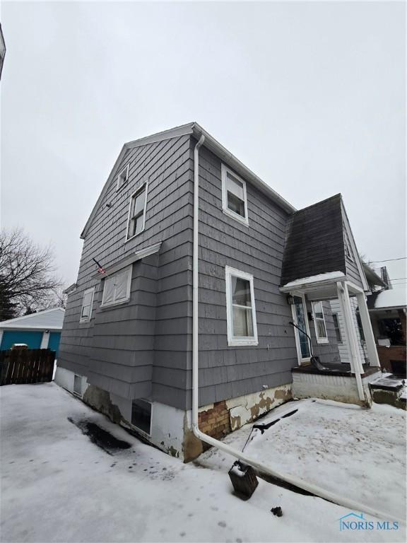 view of snowy exterior featuring fence