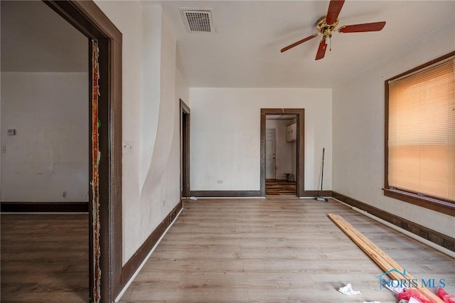 unfurnished bedroom featuring a ceiling fan, light wood-style flooring, visible vents, and baseboards