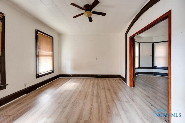 unfurnished room with a ceiling fan, light wood-type flooring, and baseboards