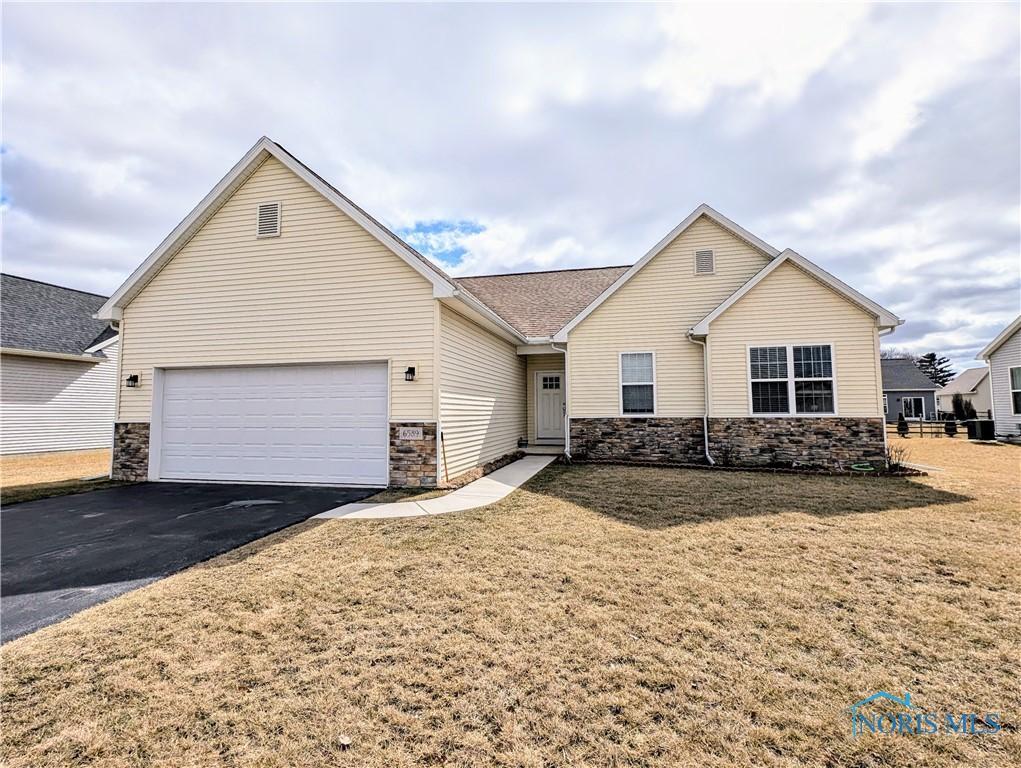 ranch-style house with a garage, stone siding, and aphalt driveway