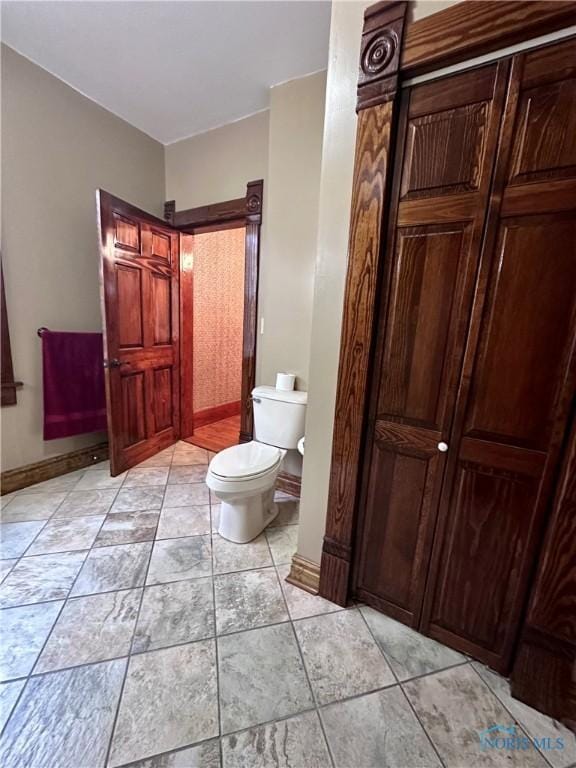 bathroom with toilet and baseboards