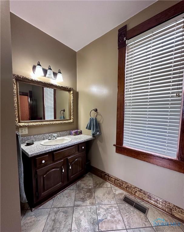 bathroom featuring baseboards, visible vents, tile patterned flooring, and vanity