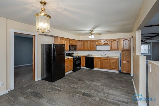 kitchen featuring ceiling fan with notable chandelier, wood finish floors, a sink, light countertops, and black appliances