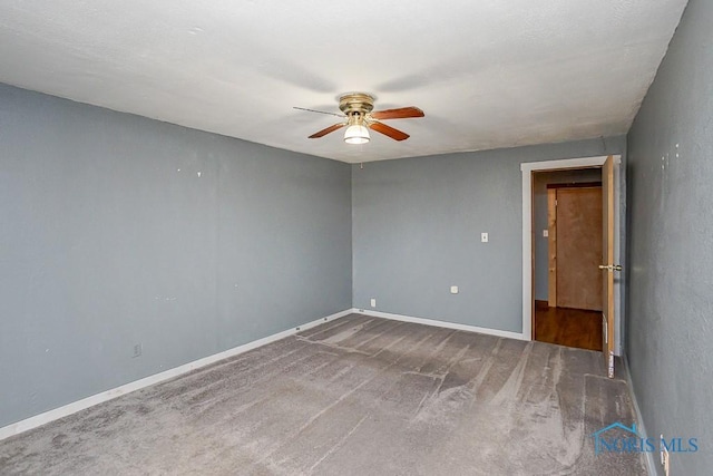 spare room with carpet floors, a ceiling fan, and baseboards