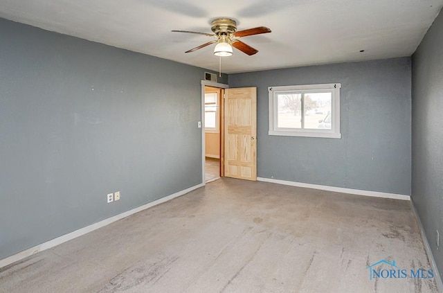 unfurnished room with a ceiling fan, visible vents, and baseboards