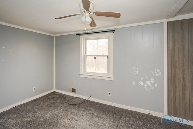 carpeted spare room with baseboards, a ceiling fan, visible vents, and crown molding