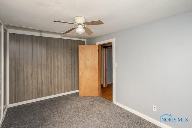 empty room with ceiling fan, carpet flooring, and baseboards