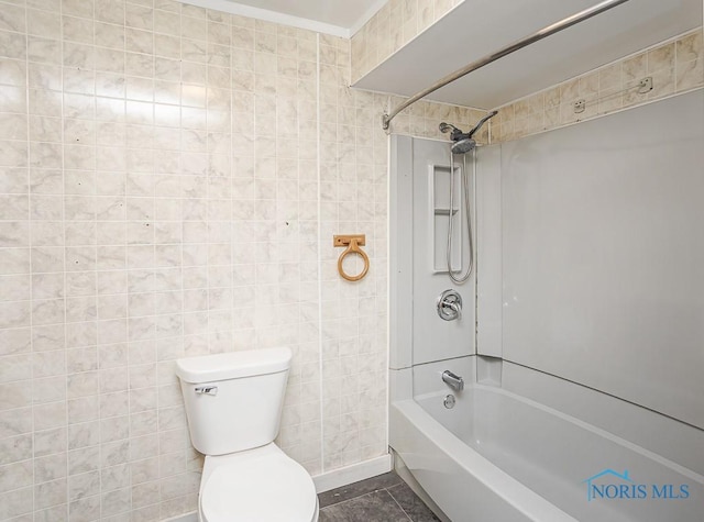 bathroom featuring  shower combination, toilet, and tile walls