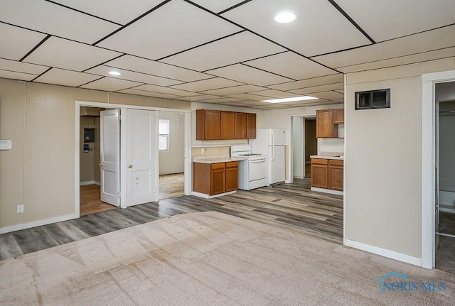 kitchen featuring carpet floors, light countertops, visible vents, brown cabinetry, and white appliances