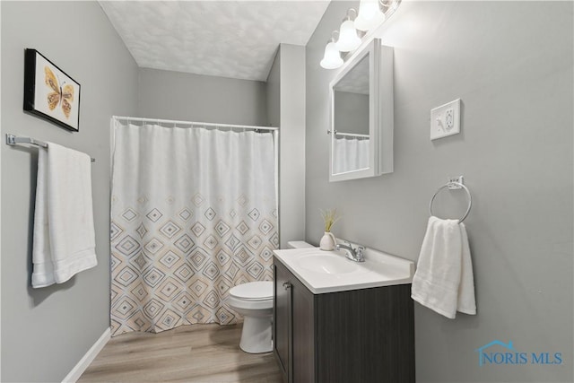 bathroom featuring vanity, a shower with shower curtain, wood finished floors, and toilet