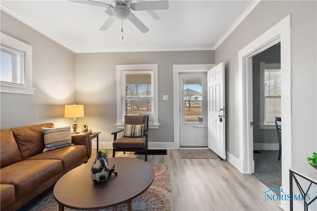 living room with light wood-style floors, crown molding, baseboards, and ceiling fan