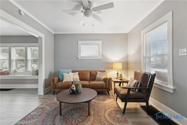 living room featuring plenty of natural light, ornamental molding, and wood finished floors